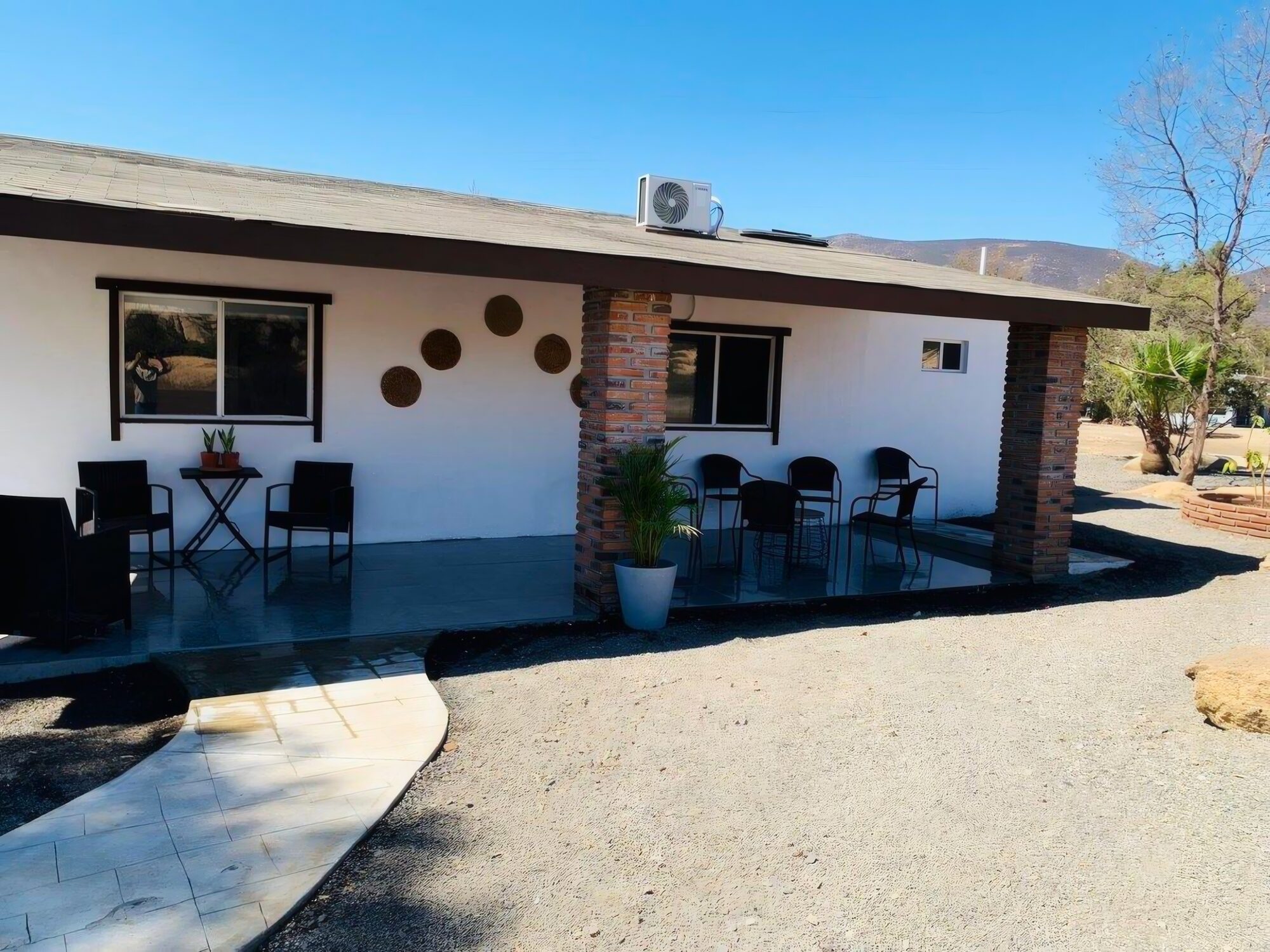 Fachada de la casa con portal y sillas al exterior